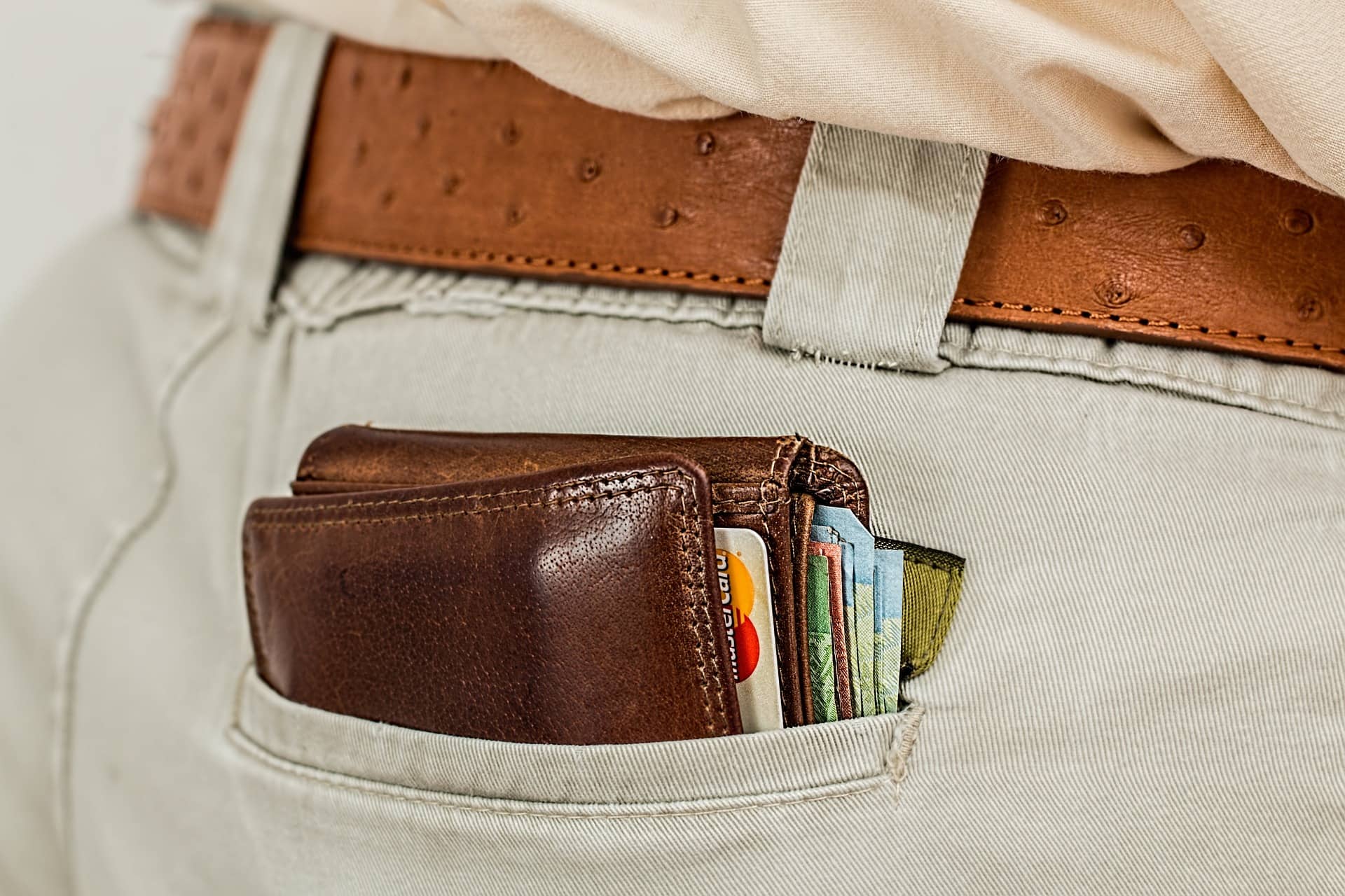 Wystający z kieszenie portfel z widocznymi kartami płatniczymi (koszty założenia spółki)